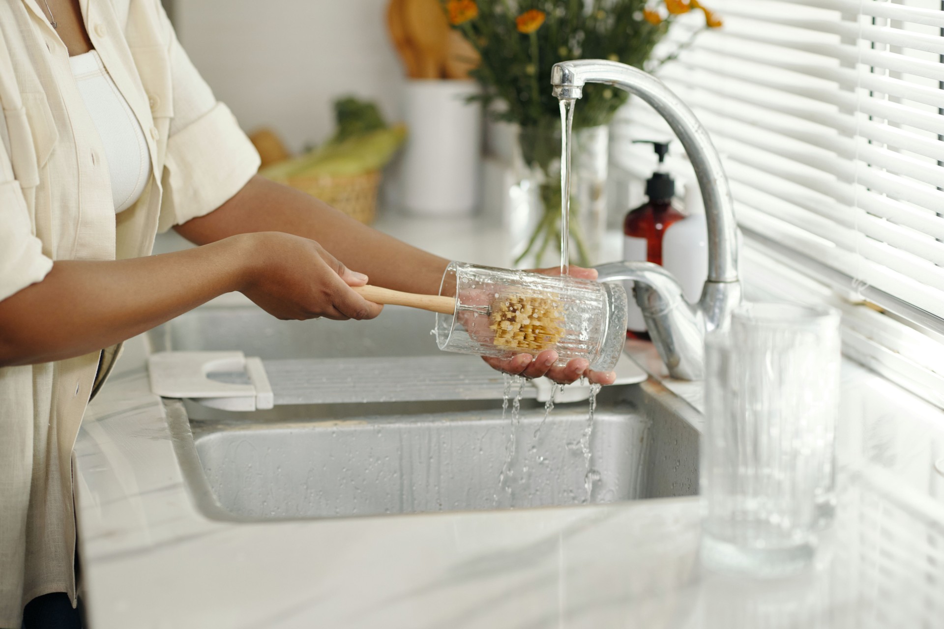 Washing Glass Cup in Modern Kitchen under Running Water
